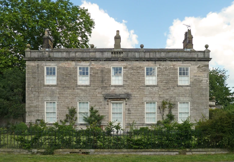 two very tall windows on an old stone building