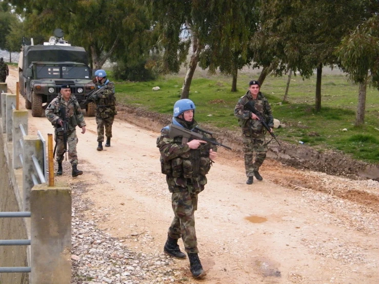 three men in military uniforms walking down the road