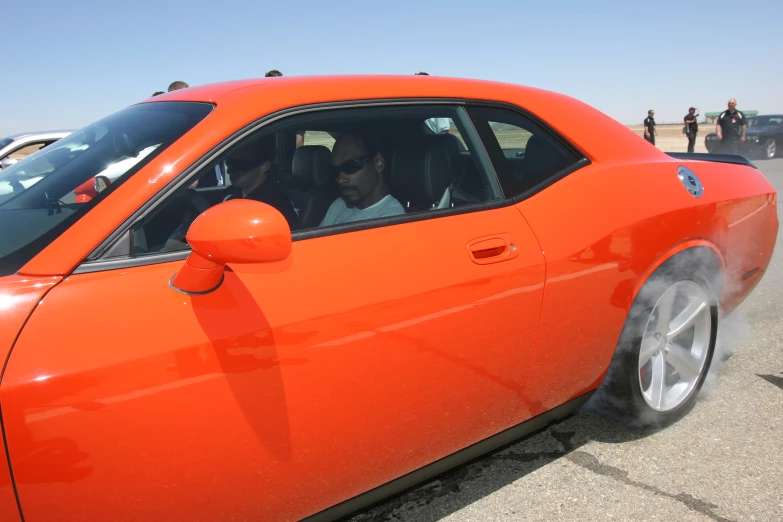 a person in an orange sports car with the door open