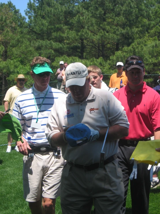 several men stand around watching a man put his glove in hand