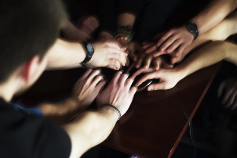 a group of people are holding their hands together