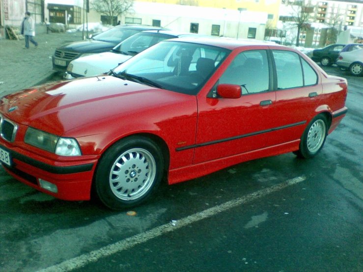 a red bmw car parked in a parking space