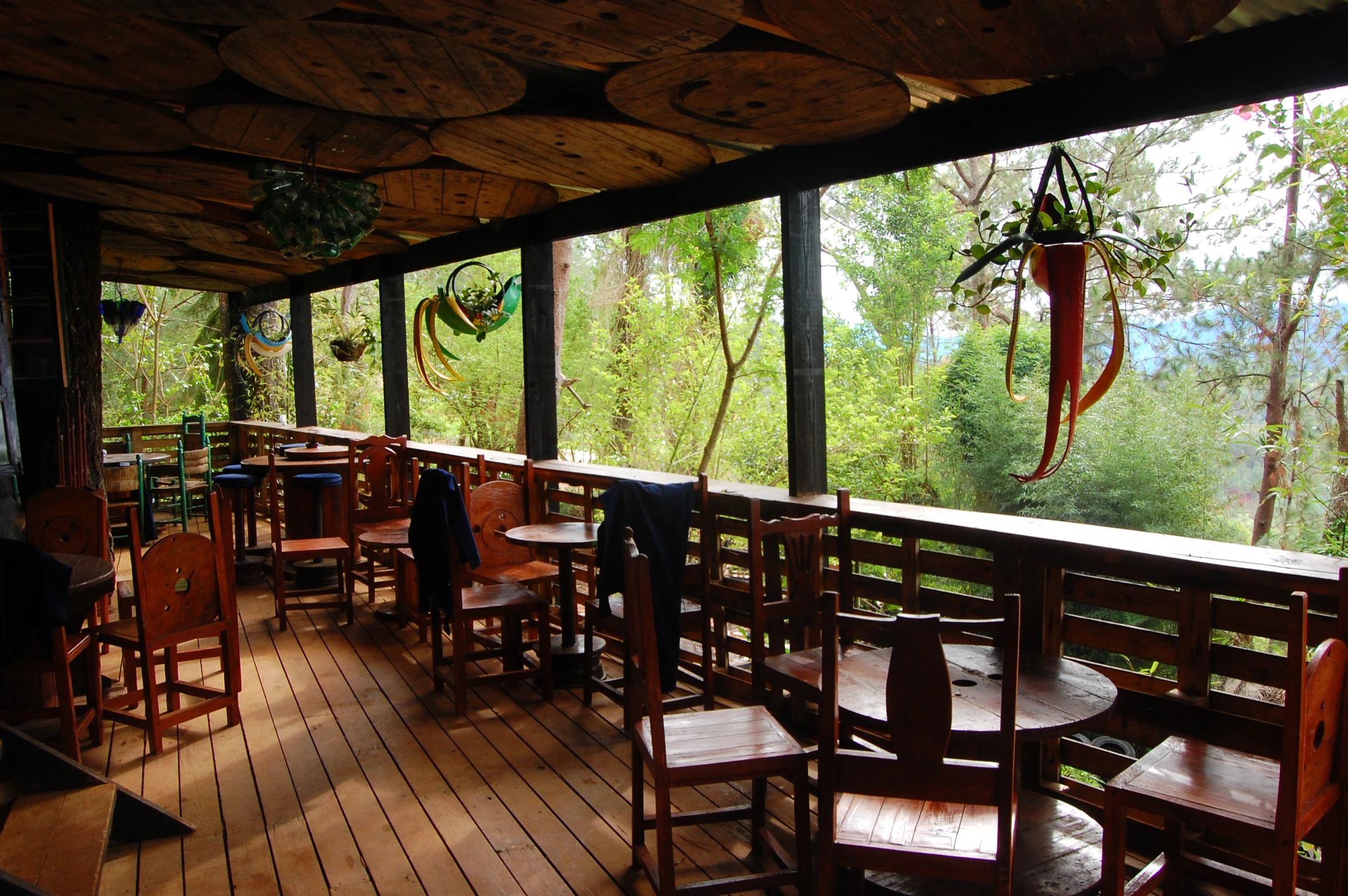 an empty wooden patio with lots of table and chairs