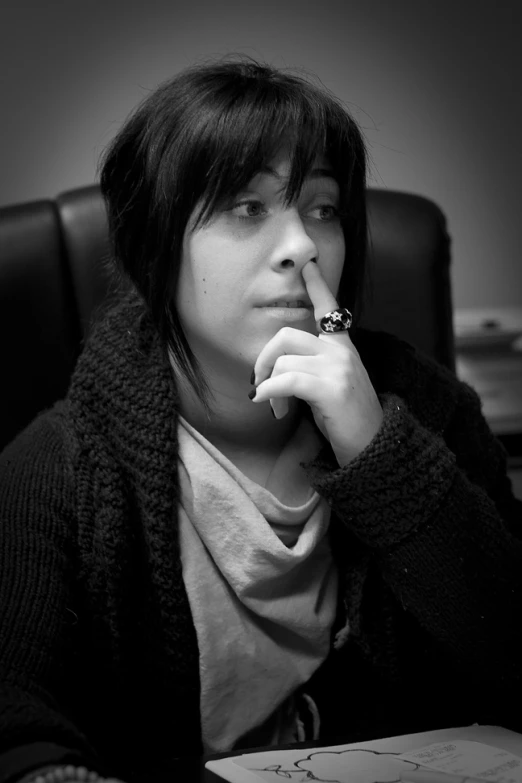 a woman sitting in a chair smoking a cigarette