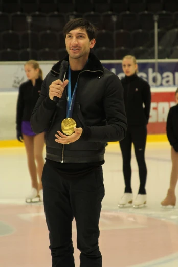 a young man is standing on the ice with a medal