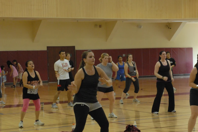 a group of people standing on a gym floor