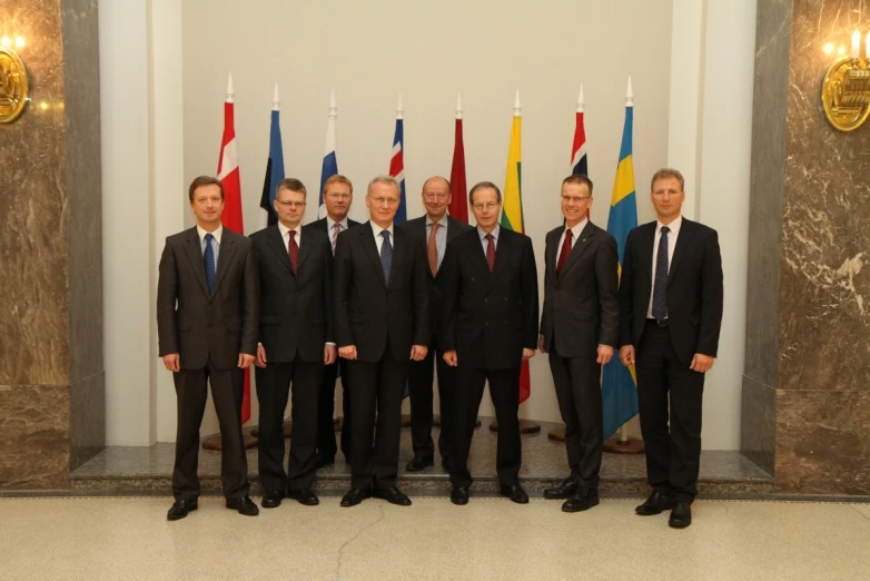 group of men standing in suits and ties with flags