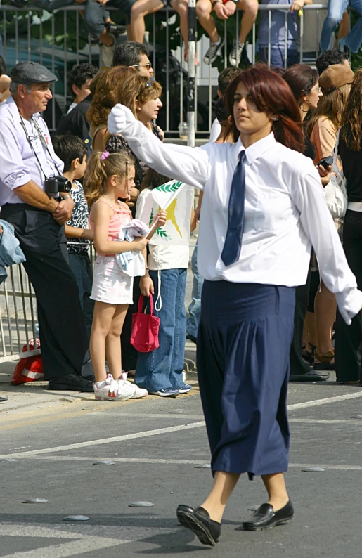 a woman in dress clothes walking down a street