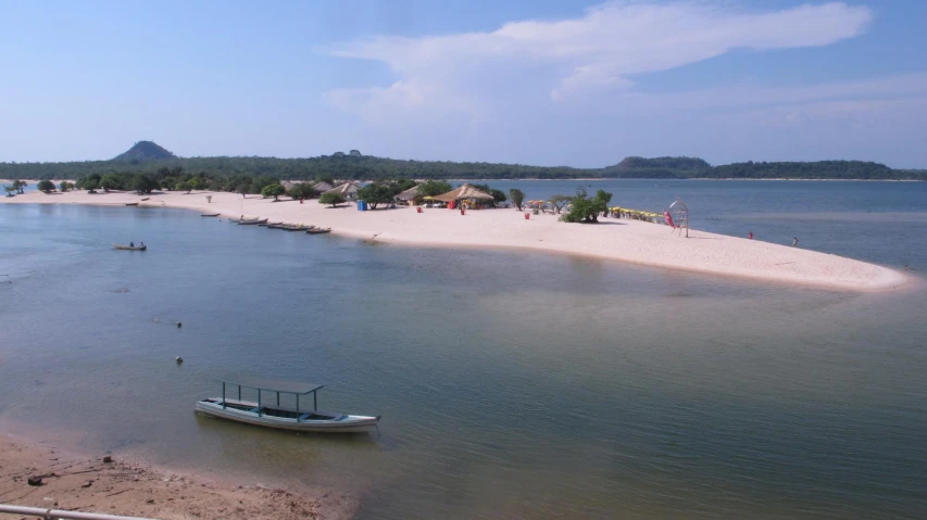 a small boat is on the beach with a dock in front