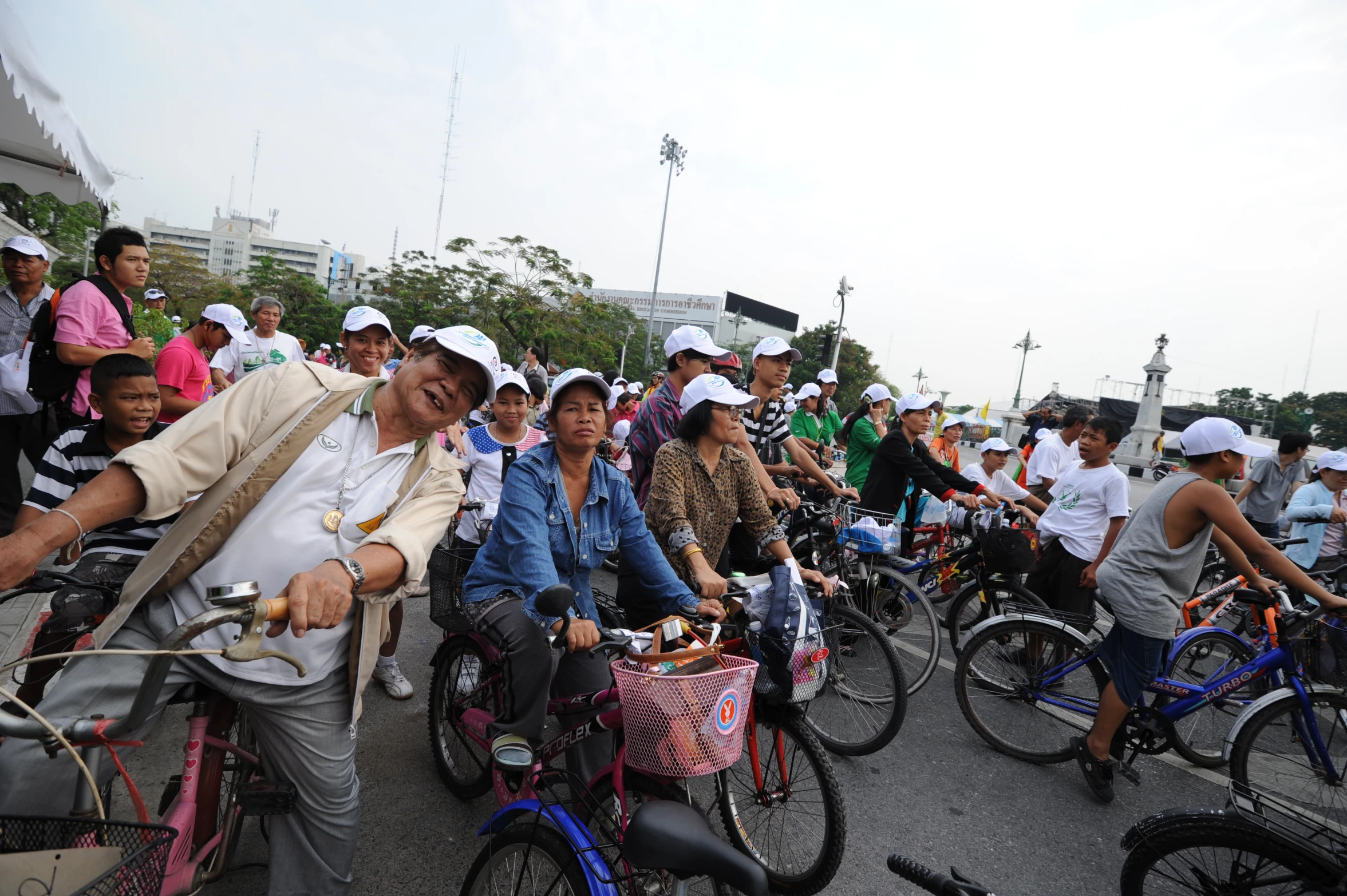 people riding bicycles along side each other with a lot of other bicyclists