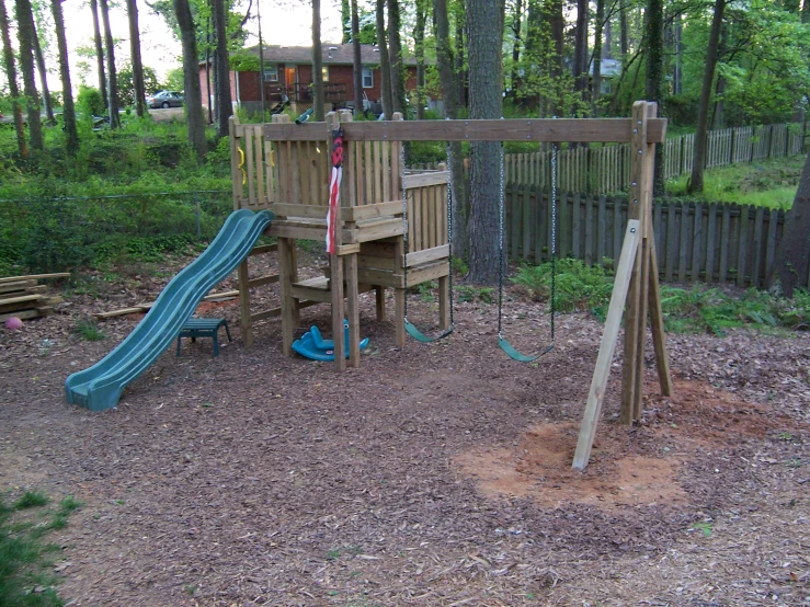 this playground is made from wood and includes a slide and climbing frame