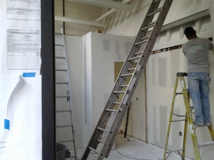 a man standing on a ladder in a room