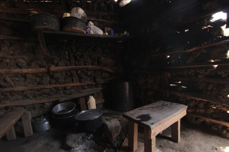 a wooden room with some buckets sitting on a bench