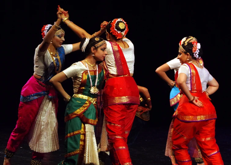 people on stage performing with one man in the center and other standing in different colors