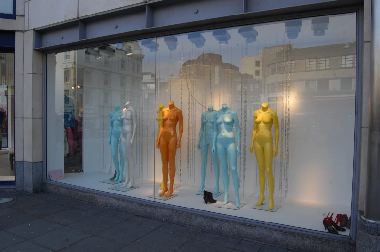 a window display with various colorful female mannequins