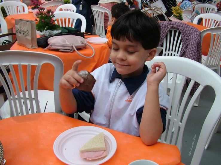 a child eating food at an outdoor table