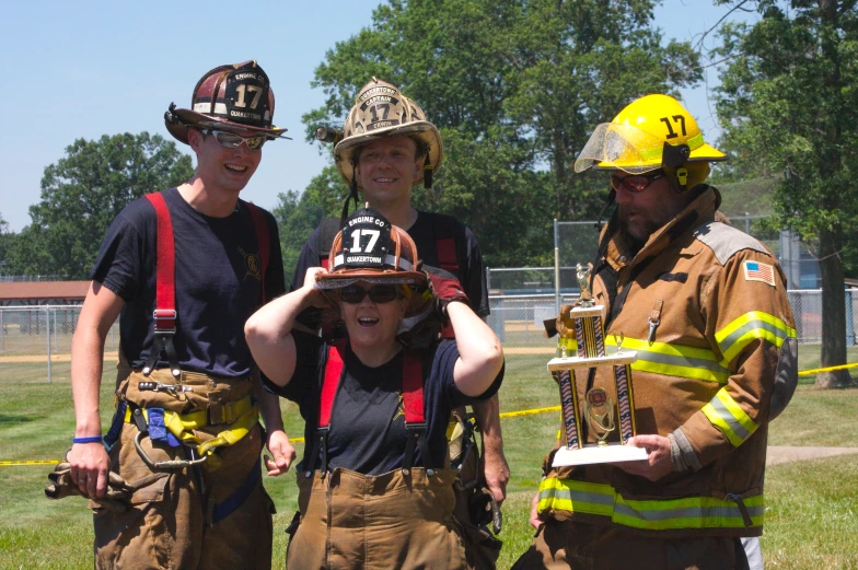 some firemen are smiling for a picture with a child