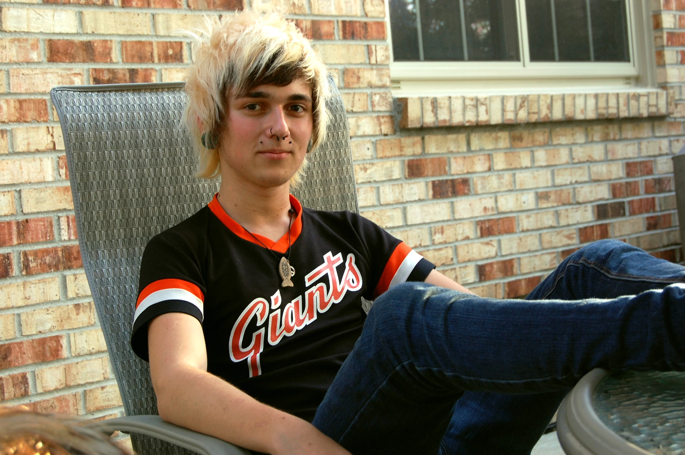 a man with his hair in the wind is sitting down