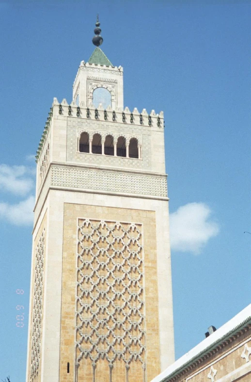 an ornately carved tower top is seen against the blue sky