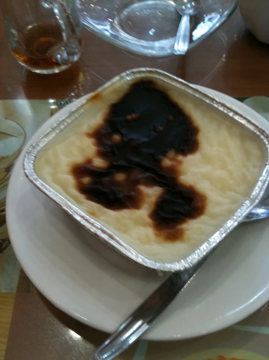 a spoon on a white plate with chocolate ding and spoon