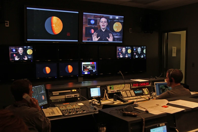 a couple of people at a control room desk