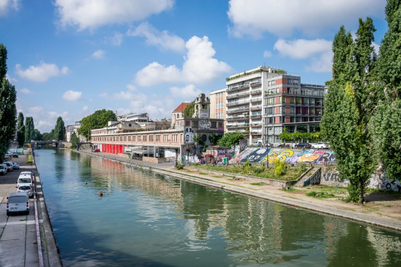 the river runs alongside a small town and it has many buildings on the banks