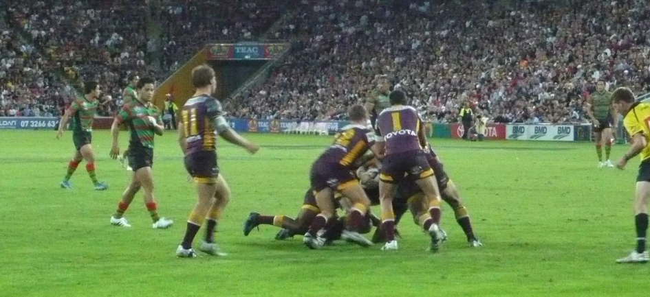 the players are playing rugby on a grass field