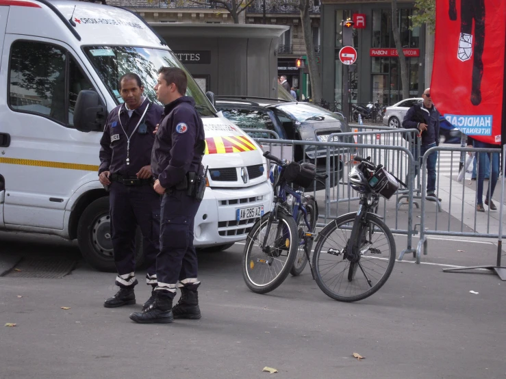 two police officers are standing near some parked bicycles