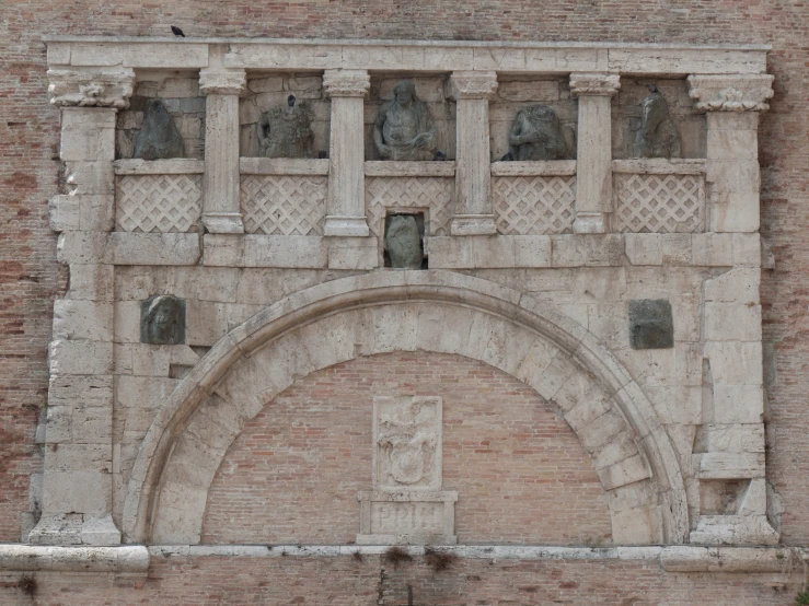 an arched window on the side of a building with statues