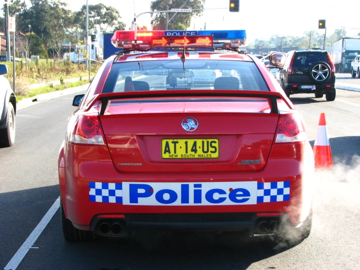 a red police car that has a blue light on top of it