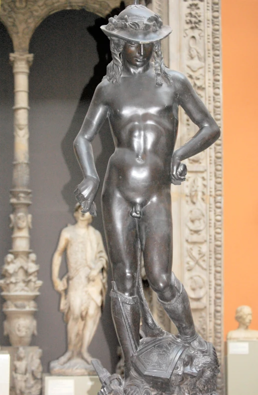 a statue in a museum wearing a hat and holding a bag