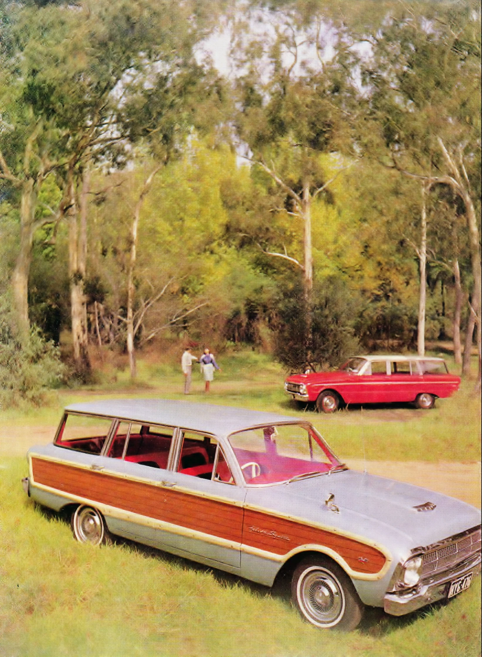 two older cars parked next to each other in the grass