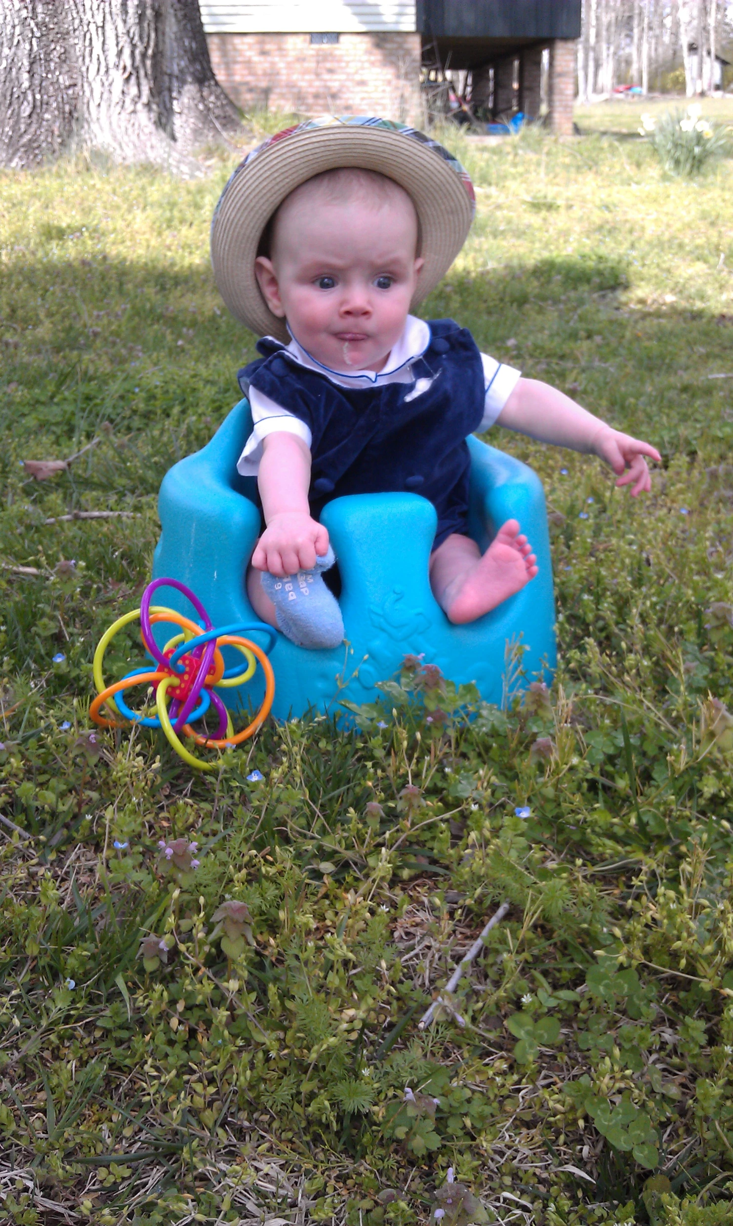 there is a baby with a hat sitting on a blue pot