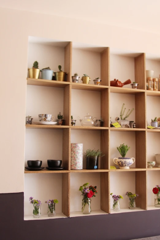 wooden shelves holding various pots and flowers on each shelf