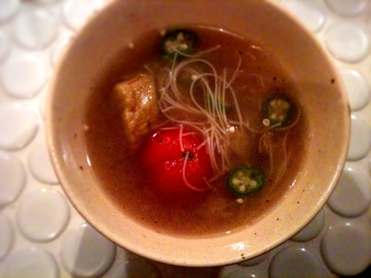 a bowl filled with soup and noodles sitting on top of a counter