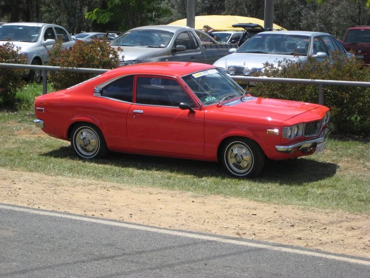 a red car is parked in the grass