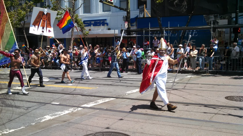 a parade is shown with people dancing and holding flags