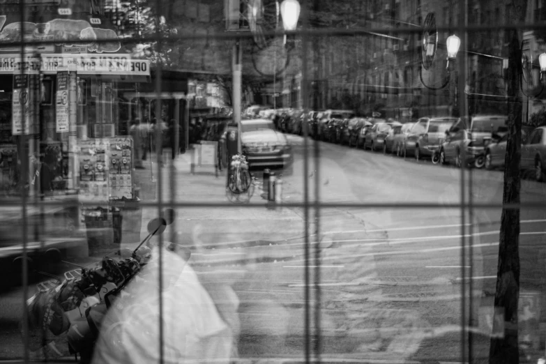 a black and white image of city street seen through window