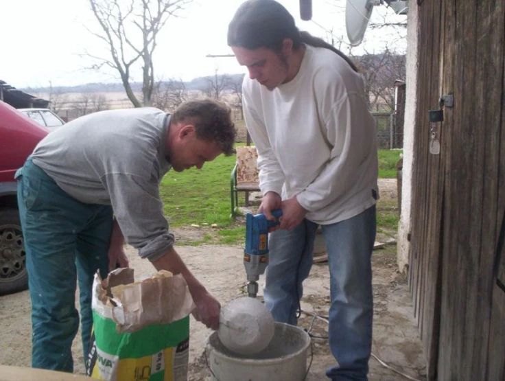 two men are working on soing with cement