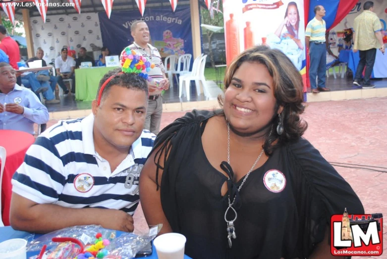 two people sitting next to each other smiling for a po