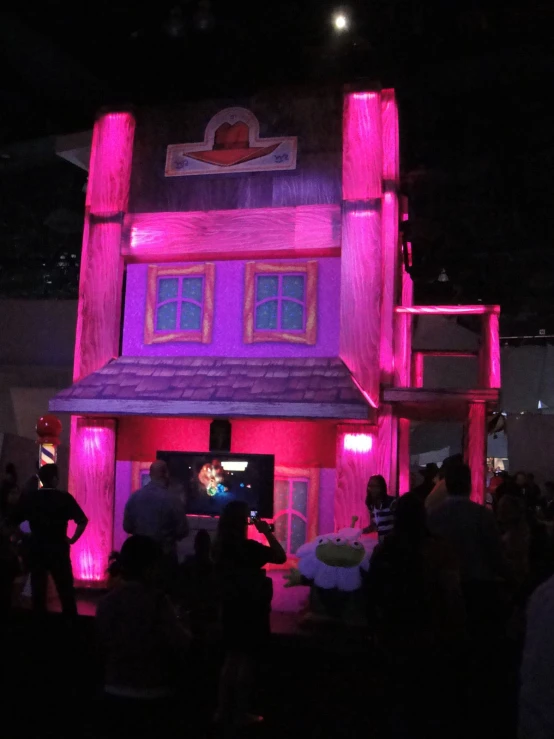 people in front of a building that has purple light