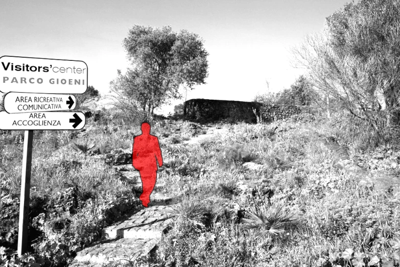 a red figure stands beneath a sign to patrol travelers