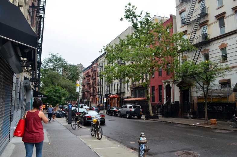 an urban sidewalk lined with parked bicycles and tall buildings