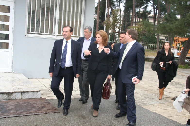 a group of people walking past each other wearing business attire