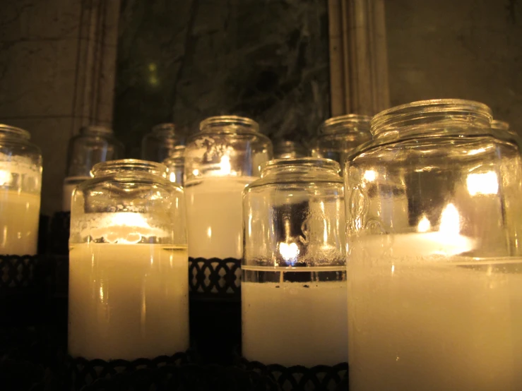 the jars in the glass are full of white candles