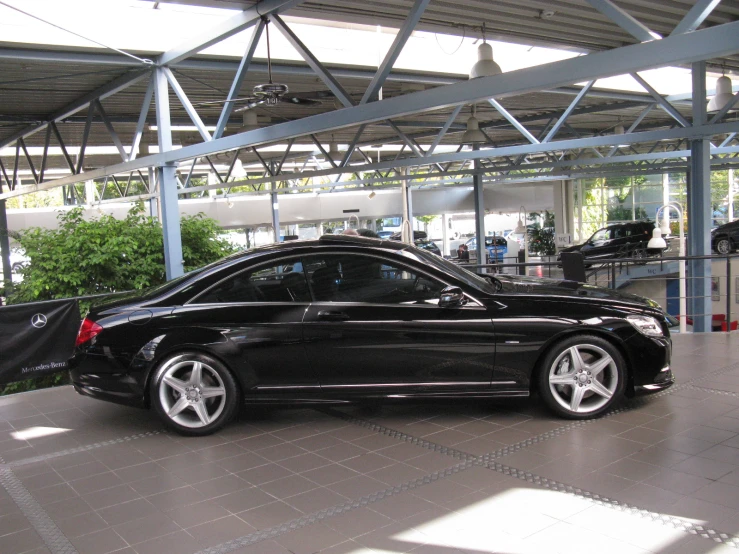 a black car in a garage with white rims