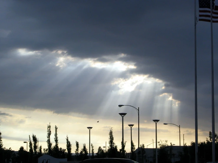the sun shines through dark clouds over the parking lot