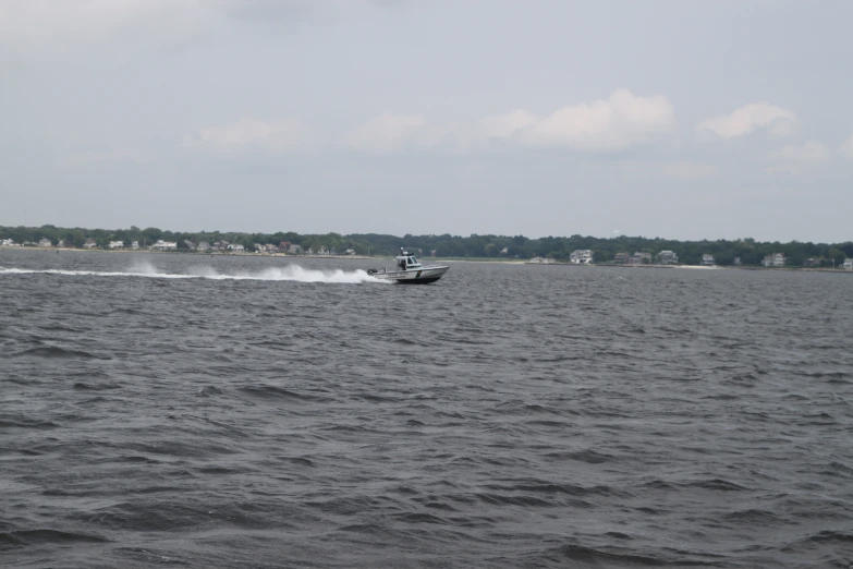 a boat on the water and the sky is grey