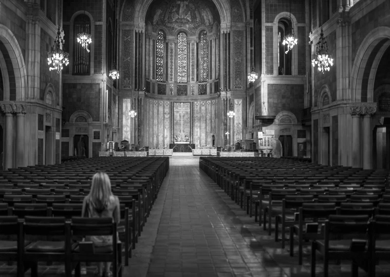 black and white pograph of cathedral with pews looking toward stage