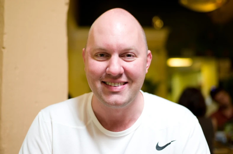 a man with a bald head wearing a white shirt